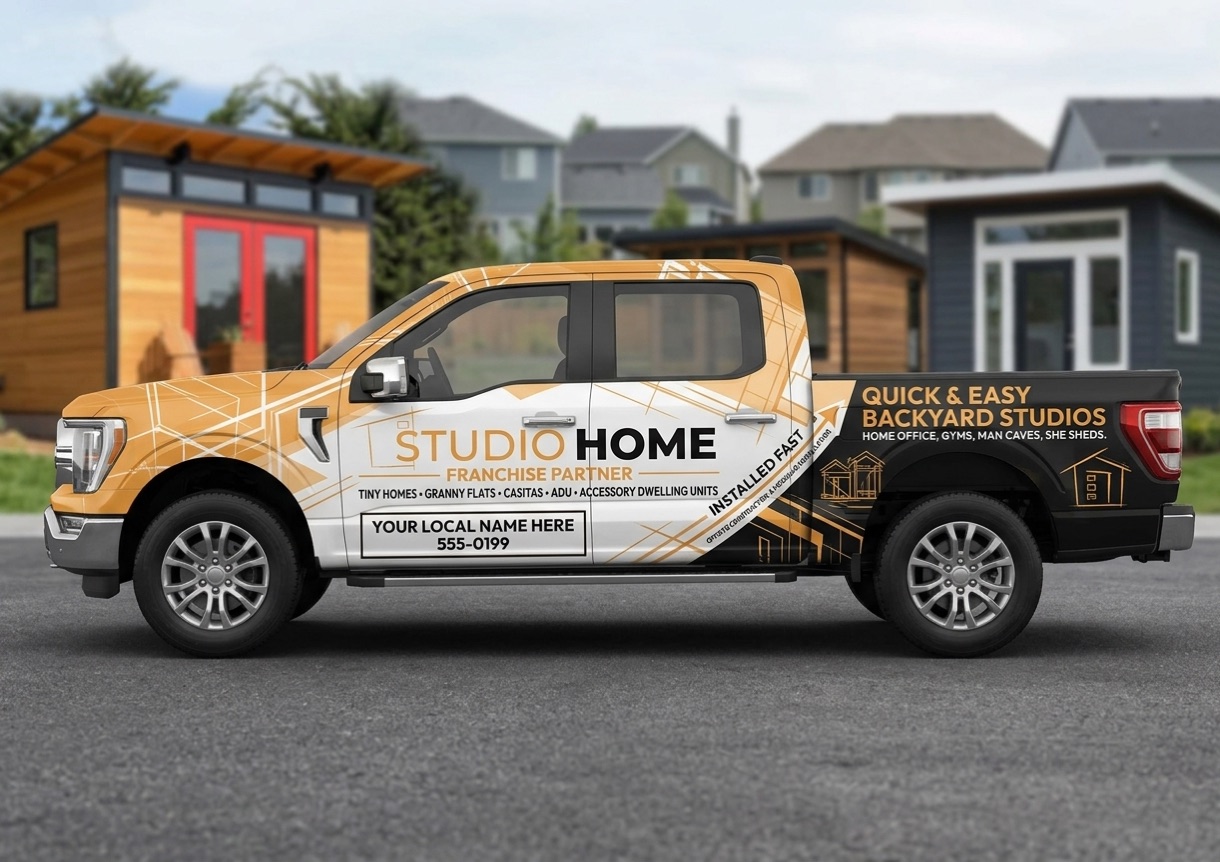 Studio Home franchise partner wrap on a Ford F-150 in topaz and white, parked on a residential street in front of two completed backyard studios.